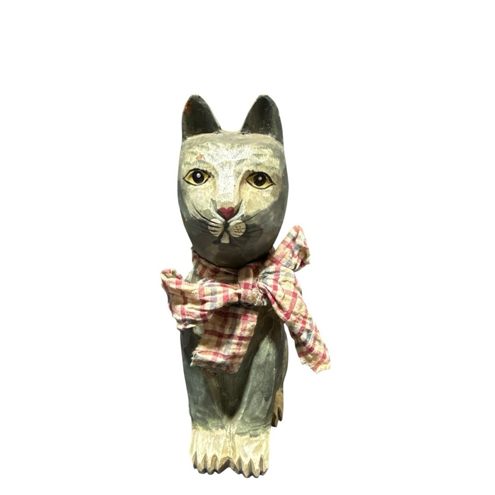 hand-carved wooden cat figurine with a painted finish and a plaid cloth scarf.